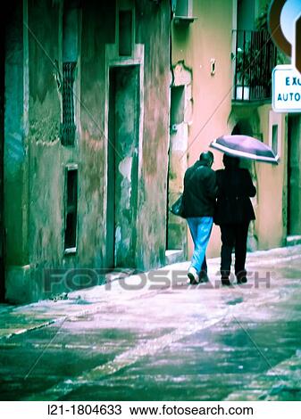 Stock Image - Couple under an umbrella, street. Tarragona, Catalonia, Spain.. Fotosearch