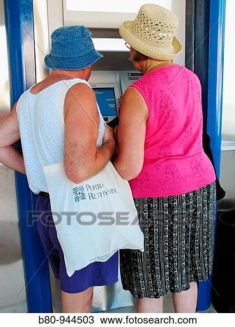 Couple using ATM, Crete, Greece View Large Photo Image Stock Image - Couple using ATM, Crete, Greece. Fotosearch