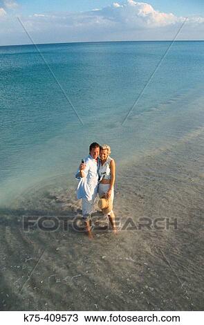 Couple using camera phone on beach View Large Photo Image Stock Image - Couple using camera phone on beach. Fotosearch