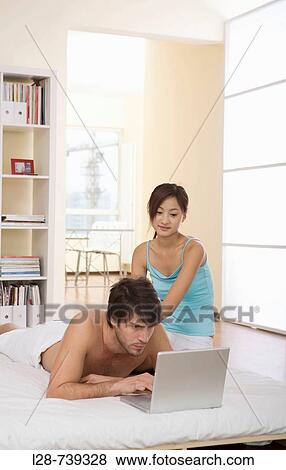 couple using computer in bed View Large Photo Image Stock Photo - couple using computer in bed. Fotosearch