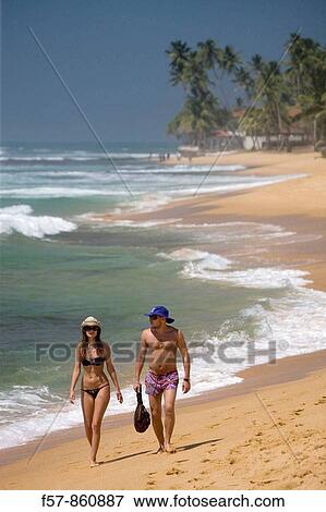 Couple walking along Hikkaduwa Beach, Sri Lanka View Large Photo Image Stock Photo - Couple walking along Hikkaduwa Beach, Sri Lanka. Fotosearch