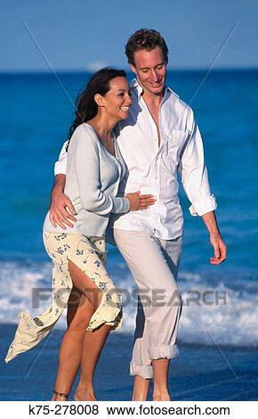 couple walking along the shoreline View Large Photo Image Stock Photo - couple walking along the shoreline. Fotosearch