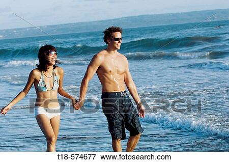 couple walking and sightseeing on beach View Large Photo Image Stock Photo - couple walking and sightseeing on beach. Fotosearch