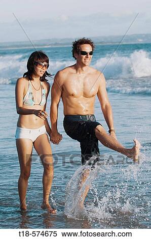 couple walking and sightseeing on beach View Large Photo Image Stock Photography - couple walking and sightseeing on beach. Fotosearch