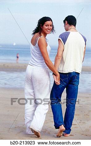 Stock Image - Couple walking by the beach. Hendaye. France. Fotosearch