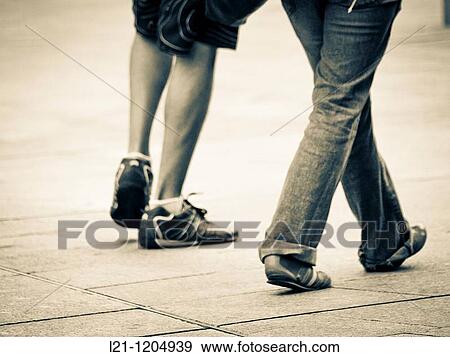 Couple walking down the street View Large Photo Image Stock Photo - Couple walking down the street. Fotosearch