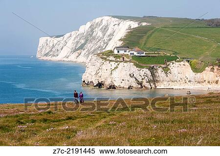 Stock Photography - Couple walking hand in hand along the cliff tops on the west wight coastal route at freshwater on the isle of white UK.. Fotosearch