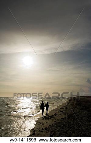 Couple walking hand-in-hand down Bowman's Beach - Sanibel Island, Florida View Large Photo Image Stock Photo - Couple walking hand-in-hand down Bowman's Beach - Sanibel Island, Florida. Fotosearch