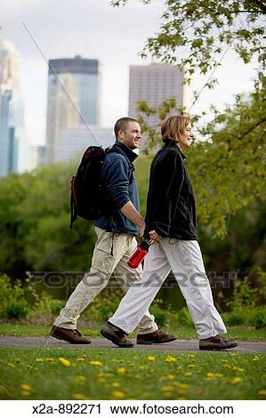 Stock Image - COUPLE WALKING IN MINNEAPOLIS PARK. Fotosearch