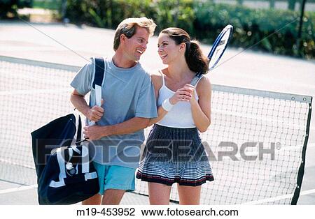 Stock Image - couple walking off a tennis court. Fotosearch