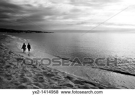 Couple walking on beach, Mataro, Catalonia, Spain View Large Photo Image Stock Photo - Couple walking on beach, Mataro, Catalonia, Spain. Fotosearch