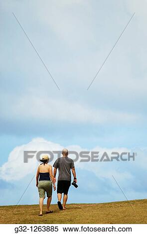 Couple walking to top of hill View Large Photo Image Stock Photography - Couple walking to top of hill. Fotosearch