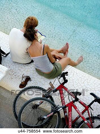 Couple with bycicles having a rest on the water View Large Photo Image Picture - Couple with bycicles having a rest on the water. Fotosearch