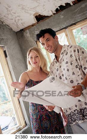 Couple with construction plans View Large Photo Image Stock Image - Couple with construction plans. Fotosearch
