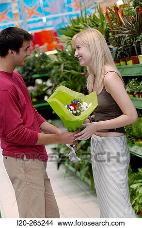 Couple with flower bouquet at shopping center View Large Photo Image Picture - Couple with flower bouquet at shopping center. Fotosearch