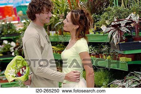 Stock Image - Couple with flower bouquet at shopping center. Fotosearch