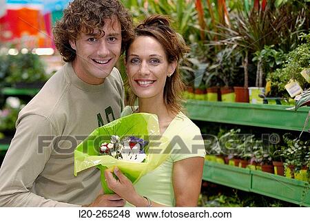Couple with flower bouquet at shopping center View Large Photo Image Stock Photo - Couple with flower bouquet at shopping center. Fotosearch