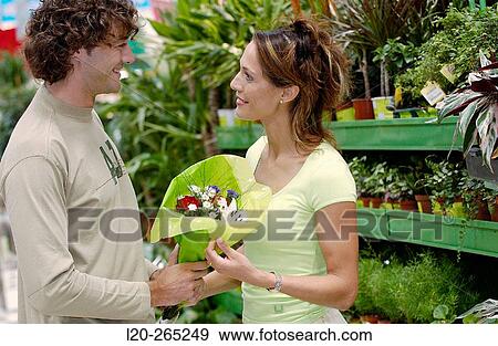 Couple with flower bouquet at shopping center View Large Photo Image Stock Photo - Couple with flower bouquet at shopping center. Fotosearch