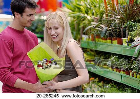 Couple with flower bouquet at shopping center View Large Photo Image Stock Photography - Couple with flower bouquet at shopping center. Fotosearch