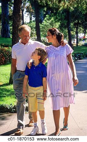 Couple with pregnant woman and boy strolling in park View Large Photo Image Stock Image - Couple with pregnant woman and boy strolling in park. Fotosearch