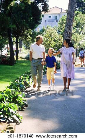 Couple with pregnant woman and boy strolling in park View Large Photo Image Stock Photo - Couple with pregnant woman and boy strolling in park. Fotosearch