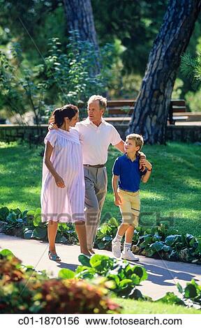 Couple with pregnant woman and boy strolling in park View Large Photo Image Stock Photograph - Couple with pregnant woman and boy strolling in park. Fotosearch