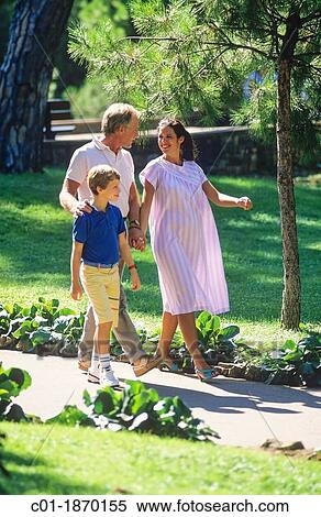 Couple with pregnant woman and boy strolling in park View Large Photo Image Stock Photography - Couple with pregnant woman and boy strolling in park. Fotosearch