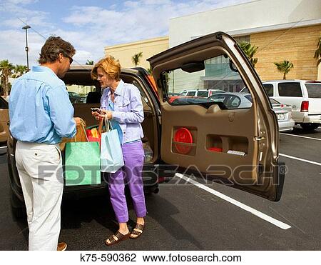 Couple with shopping bags at their SUV. View Large Photo Image Stock Image - Couple with shopping bags at their SUV.. Fotosearch