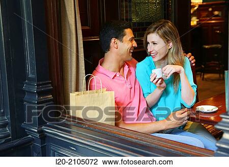 Stock Image - Couple with shopping bags in a coffee bar. San Sebastian. Donostia. Gipuzkoa. Basque Country. Spain.. Fotosearch