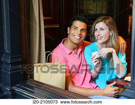 Stock Image - Couple with shopping bags in a coffee bar. San Sebastian. Donostia. Gipuzkoa. Basque Country. Spain.. Fotosearch