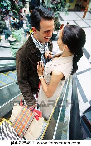 Couple with shopping bags on scalator in shopping mall View Large Photo Image Stock Image - Couple with shopping bags on scalator in shopping mall. Fotosearch