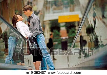 Couple with shopping bags on scalator in shopping mall View Large Photo Image Stock Photo - Couple with shopping bags on scalator in shopping mall. Fotosearch