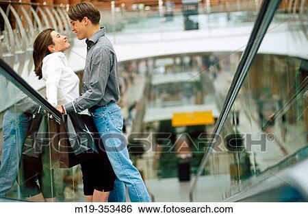 Couple with shopping bags on scalator in shopping mall View Large Photo Image Stock Photograph - Couple with shopping bags on scalator in shopping mall. Fotosearch