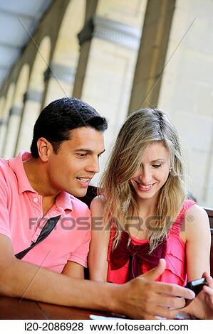 Couple with smartphone at a restaurant. San Sebastian. Donostia. Gipuzkoa. Basque Country. Spain. View Large Photo Image Stock Photo - Couple with smartphone at a restaurant. San Sebastian. Donostia. Gipuzkoa. Basque Country. Spain.. Fotosearch