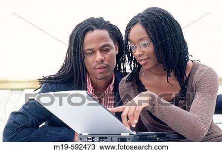 Stock Image - couple working on a laptop. Fotosearch