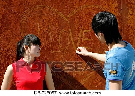 Couple writing? love? in chalk on wall, close-up View Large Photo Image Stock Photo - Couple writing? love? in chalk on wall, close-up. Fotosearch
