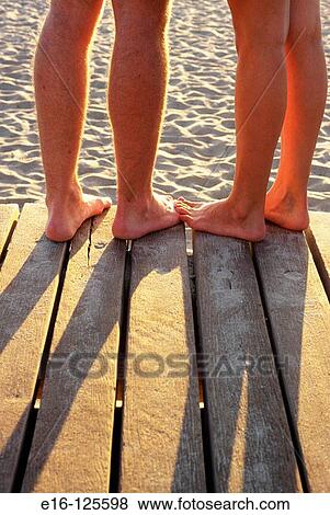 Couple's feet together at beach boardwalk View Large Photo Image Stock Photo - Couple's feet together at beach boardwalk. Fotosearch