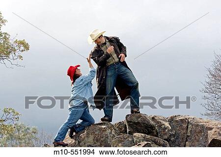 Cowboy and cowgirl showing affection, playful acting on the rocks in the country during spring View Large Photo Image Picture - Cowboy and cowgirl showing affection, playful acting on the rocks in the country during spring. Fotosearch