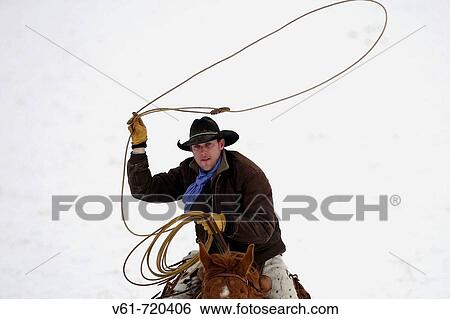 Cowboy and larieat riding through winter snow Sell, Wyoming, Usa View Large Photo Image Stock Photograph - Cowboy and larieat riding through winter snow Sell, Wyoming, Usa. Fotosearch