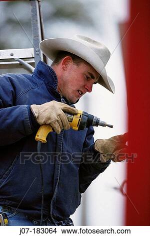 Cowboy building corral with drill. Texas. USA View Large Photo Image Picture - Cowboy building corral with drill. Texas. USA. Fotosearch