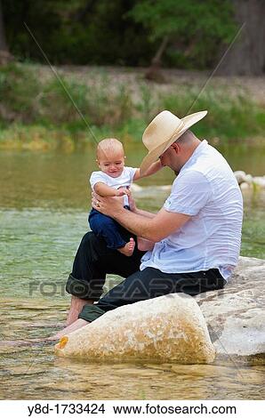 Cowboy father and his baby boy taking a bath in the Frio River, Texas View Large Photo Image Picture - Cowboy father and his baby boy taking a bath in the Frio River, Texas. Fotosearch