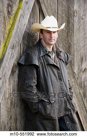 Cowboy leaning up against the old, rugged barn looking towards you View Large Photo Image Stock Image - Cowboy leaning up against the old, rugged barn looking towards you. Fotosearch