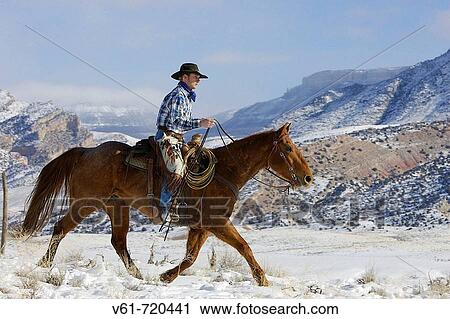Stock Image - Cowboy out for a ride in winter, Shell, Wyoming. Usa. Fotosearch