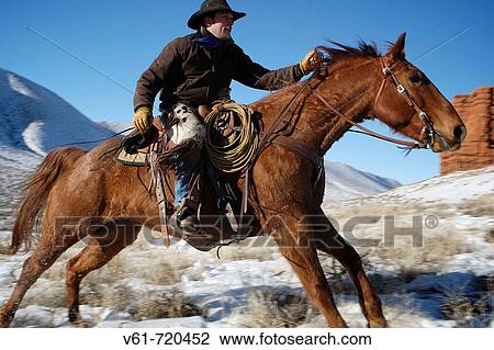 Stock Image - Cowboy out for a ride in winter, Shell, Wyoming. Usa. Fotosearch