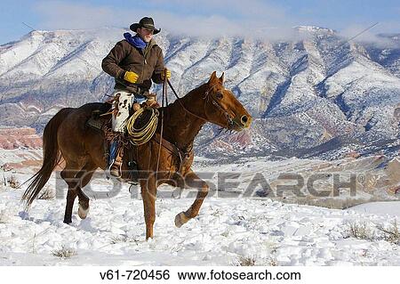 Stock Photograph - Cowboy out for a ride in winter, Shell, Wyoming. Usa. Fotosearch