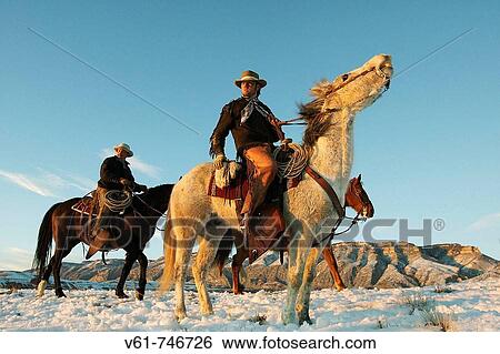 Stock Photograph - Cowboys out for a ride in winter, Shell, Wyoming, USA. Fotosearch