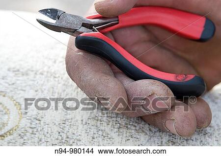 Craftsman Upholstery tanned hand gripping pliers. View Large Photo Image Picture - Craftsman Upholstery tanned hand gripping pliers.. Fotosearch