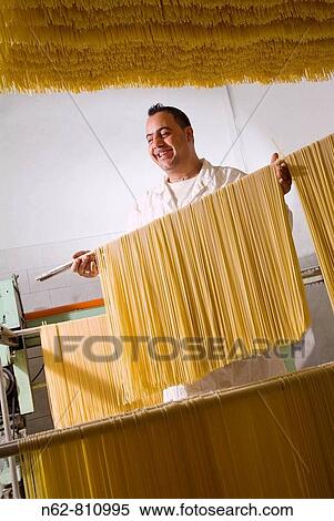 Stock Photography - craftsman who prepares typical Italian spaghetti pasta. Fotosearch