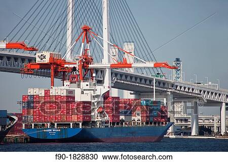 Stock Image - Crane loads containers-bridge-port-Yokohama-Japan. Fotosearch