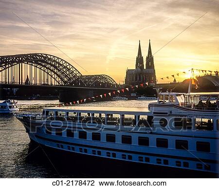 Cruise boat and Hohenzollern bridge and cathedral at sunset Cologne Germany. View Large Photo Image Stock Image - Cruise boat and Hohenzollern bridge and cathedral at sunset Cologne Germany.. Fotosearch